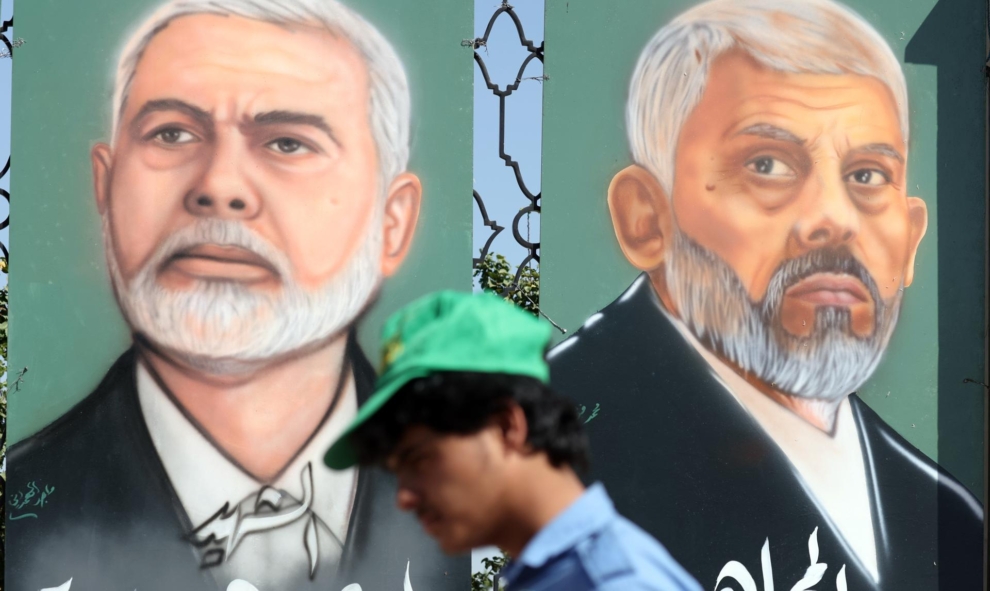 Un partisan des Houthis passe devant deux portraits de Yehia Sinwar et Ismail Haniyeh à Sanaa.