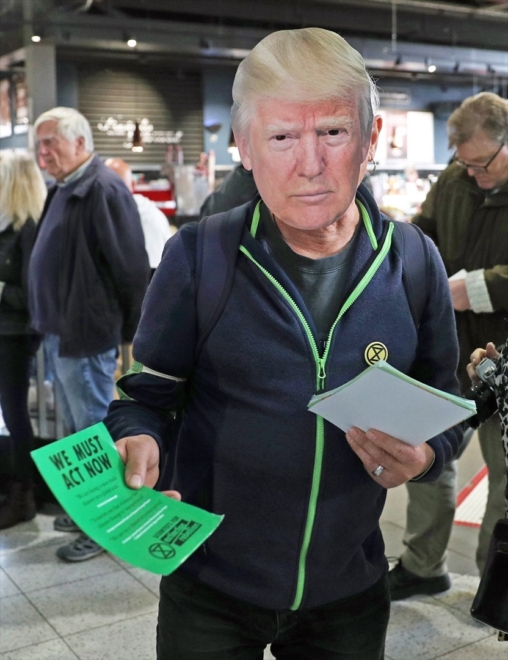 Un membre d'Extinction Rebellion distribue des tracts lors d'une manifestation.