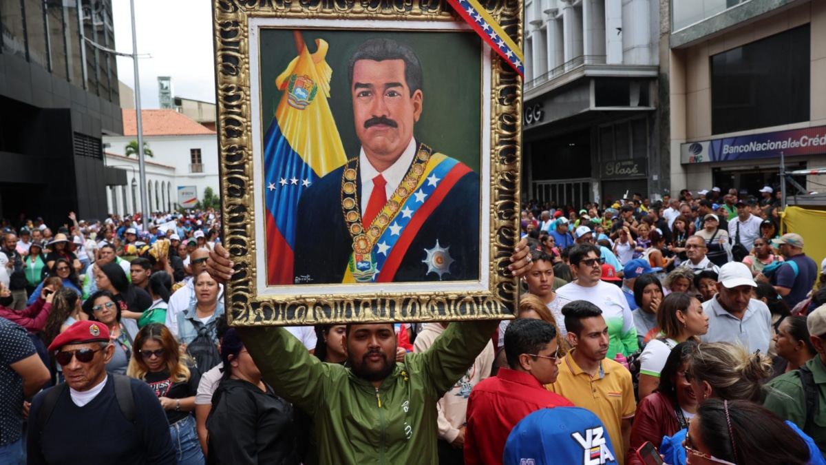 Un hombre sostiene un cuadro con la imagen del presidente de Venezuela, Nicolás Maduro, durante una marcha este jueves, en Caracas