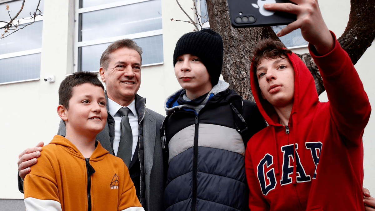 El primer ministro esloveno, Robert Golob, se hace un selfie con unos adolescentes, este domingo a la salida de su colegio electoral en Ljubljana.