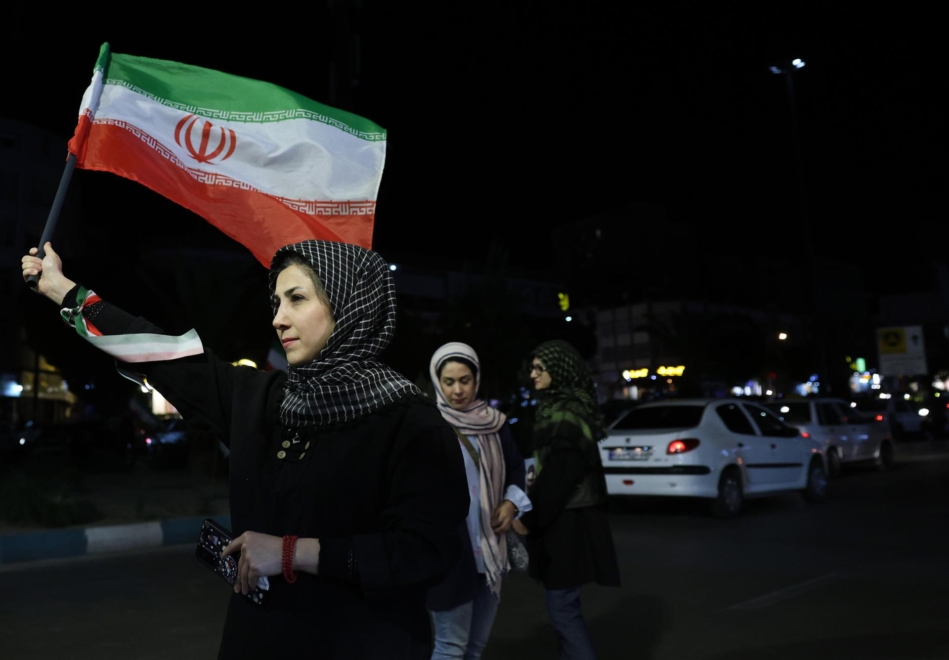 Une femme brandit le drapeau iranien dans les rues de Téhéran
