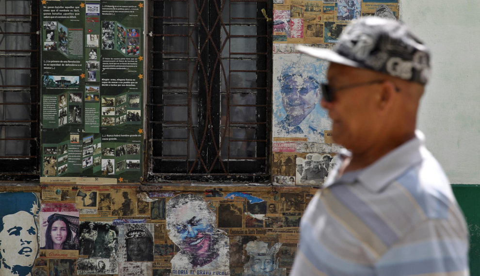 Un homme passe devant des affiches de propagande à La Havane