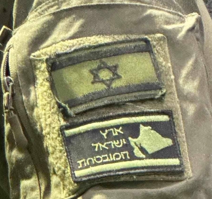 Soldat de Tsahal avec un patch qui dit : "La terre promise d'Israël".