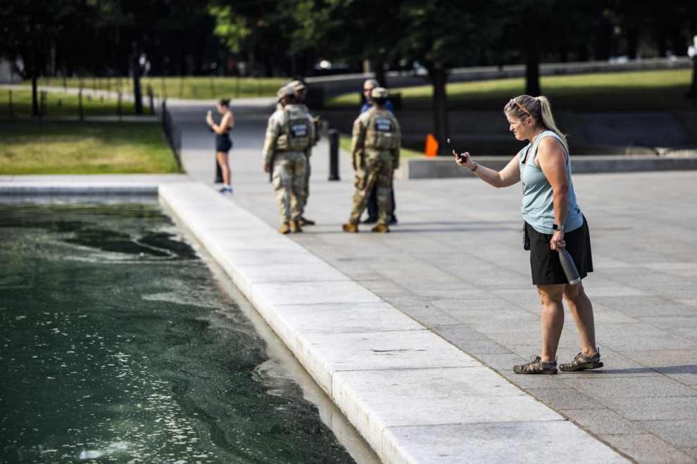 Une femme prend des photos des algues dans le Reflecting Pond